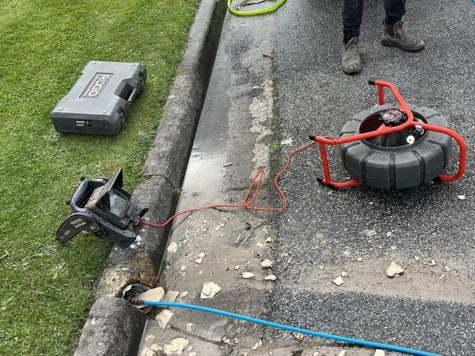 Drain cleaning hose and equipment beside a path, Chadstone