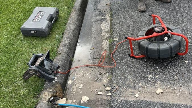 Drain cleaning hose and equipment beside a path, Chadstone